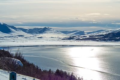 Le lac et les montagnes enneigées en Akureyri - Islande