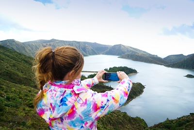 Fille prenant en photo le Lagoa do Fogo - Sao Miguel - Acores - Portugal