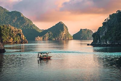 Bateau sur la baie d'halong au coucher du soleil